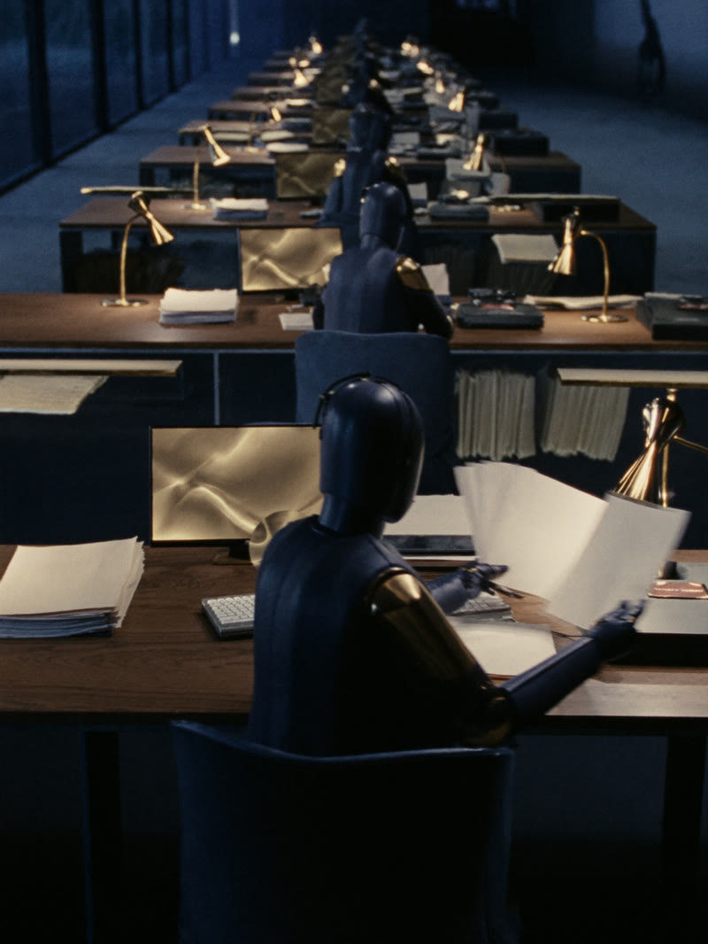 Robots at work across the desks of an office at night